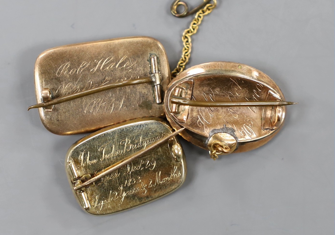 Two George III yellow metal and enamel mourning brooches, with engraved inscriptions, ? Hale, 1795 and Robert Hale, 1812 , both with plaited hair, one mounted with seed pearls(one missing) and a William IV mourning broch